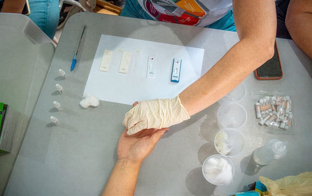 Coleta de exame de sangue por punção digital durante ação de saúde